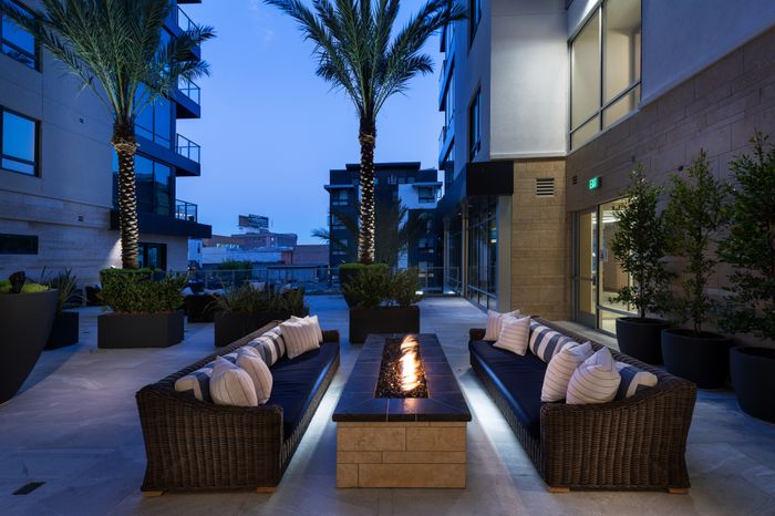 Alternate view of the outdoor firepit and seating area showing the stone material of the modern rectangular firepit.