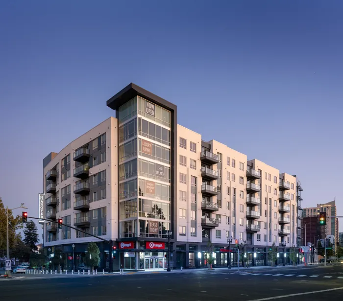 Exterior of the mid-rise Hanover Broadway building located on a street corner, with balconies on each level and a Target on the bottom floor.