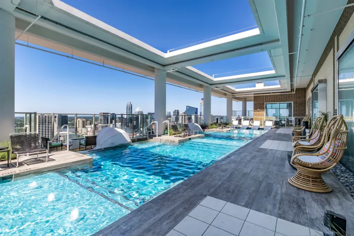 Rooftop pool deck featuring sunshelf and private cabanas