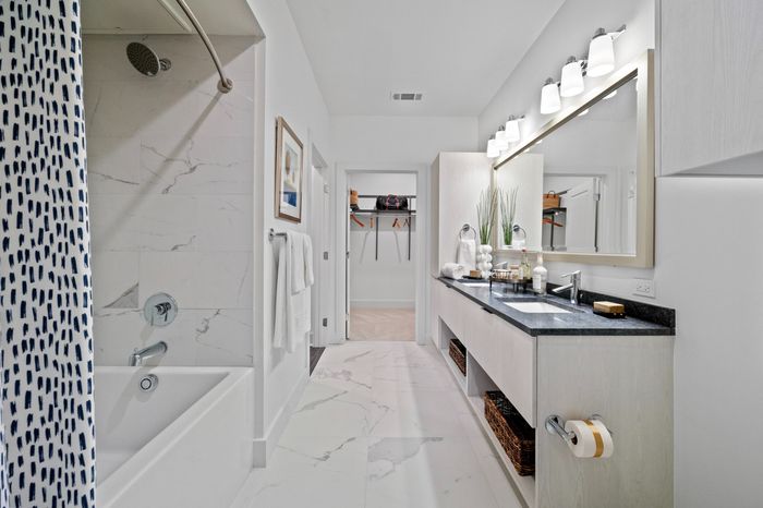 bathroom with tub and two sinks