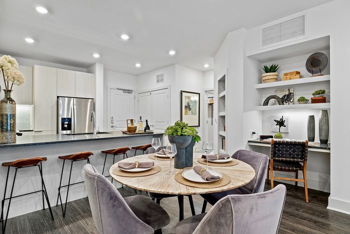 round dining table and chairs next to built in desk and counter height seating