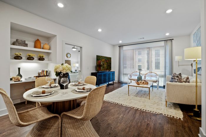 living and dining room with dark wood-style floors and built in desk