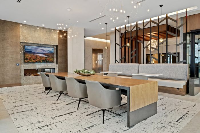 coworking table with 8 chairs and booth seating in room with fireplace and tv on wall