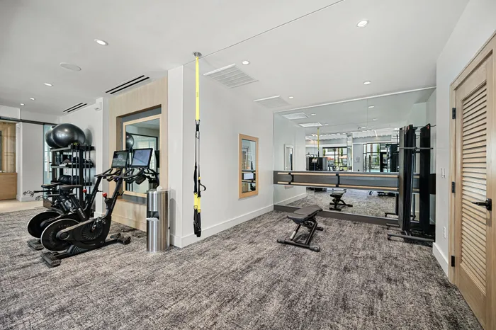 fitness center with stationary bikes trx band and fitness mirror