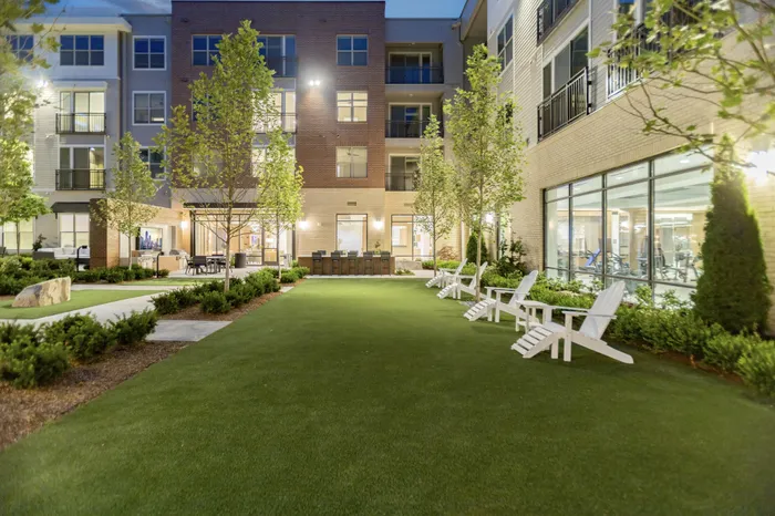 green lawn space with adirondack chairs and landscaping surrounding