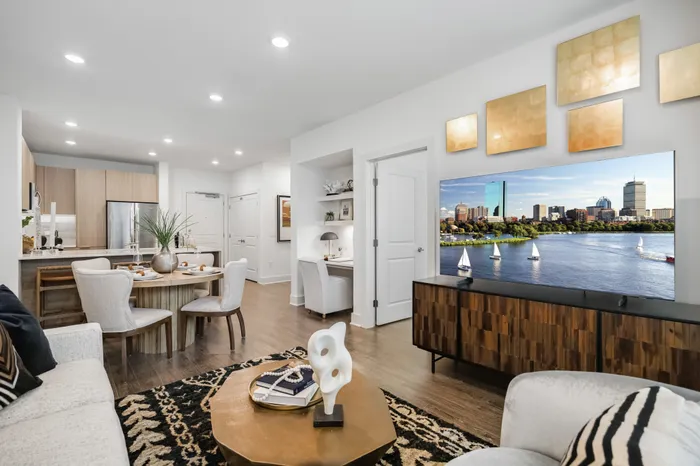 furnished apartment living and dining area with a built in desk and hardwood flooring