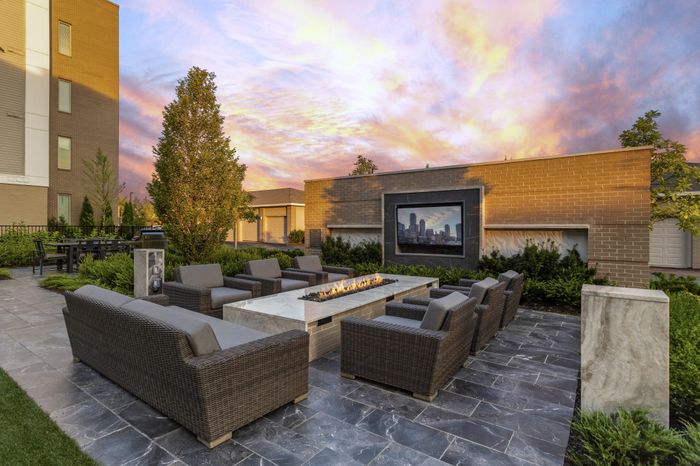 outdoor courtyard with soft lounge seating, fire pit and tvs