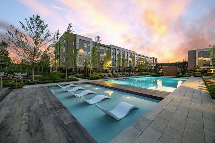 resort style pool with in-pool lounge chairs, surrounded by day beds and sun loungers