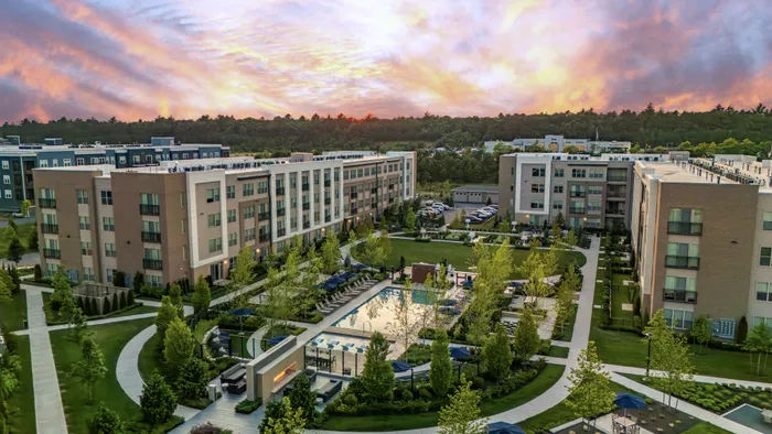birdseye view of Colony Place and the expansive courtyard with resort-style pool, fire place, ample green space and seating