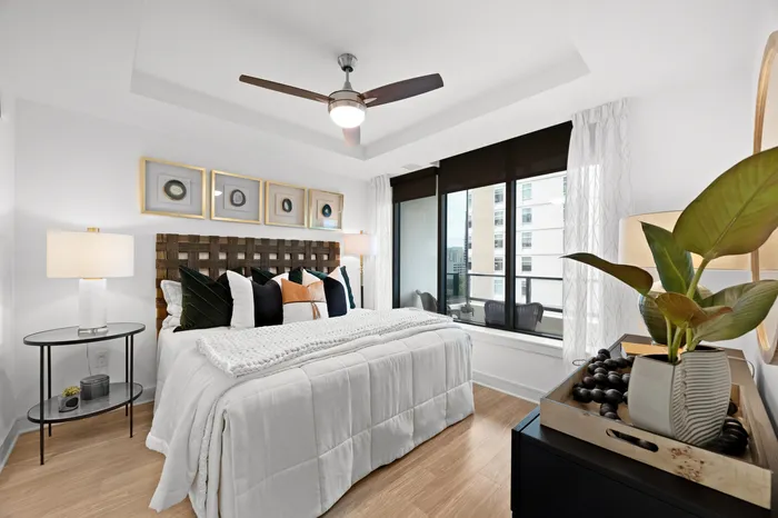 bedroom with large windows, ceiling fan and light fixture, with king-size bed, nightstands and a dresser