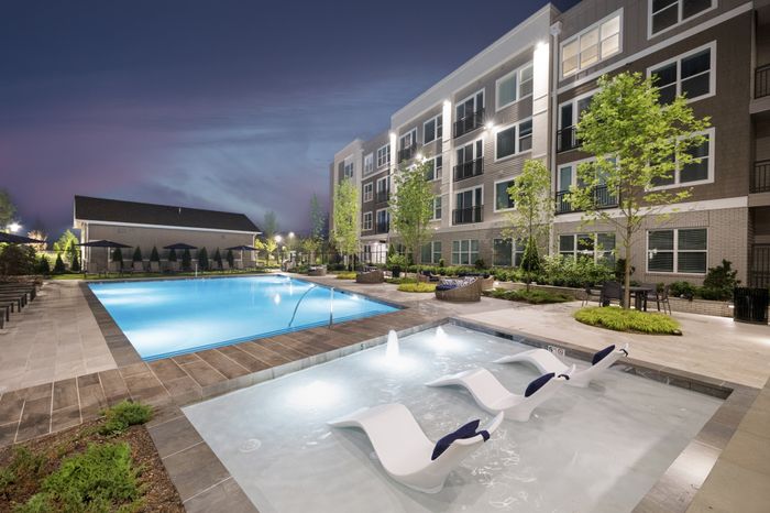 pool with shallow area with bubblers and 3 lounge chairs; pool surrounded with day beds and more lounge chairs