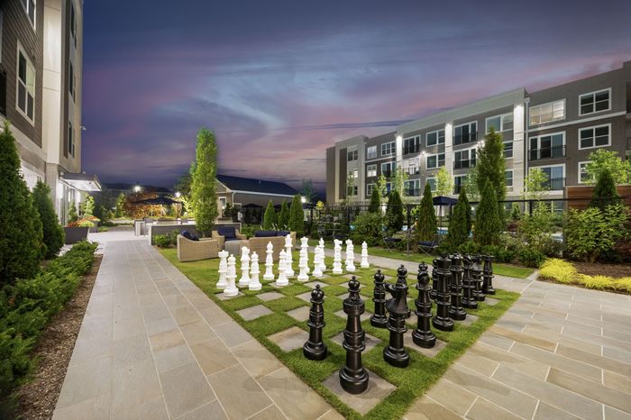 courtyard with lifesize chess game with grass and concrete chess board