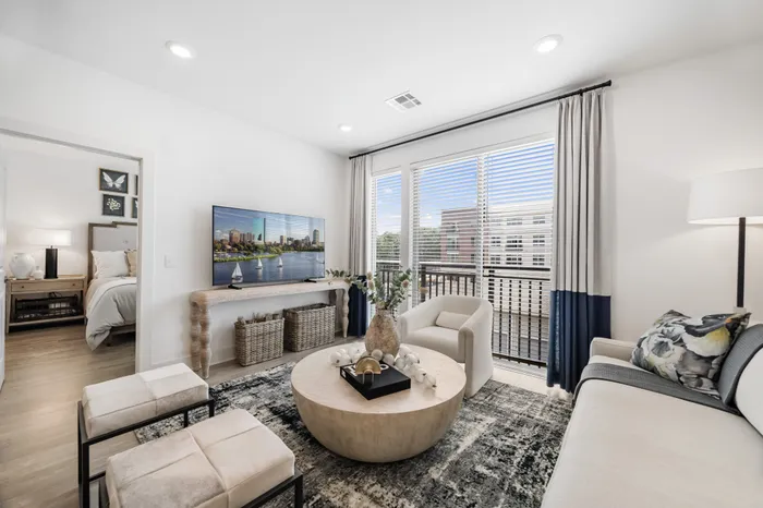 apartment living room with couch, chairs, and TV, and 3 large sliding glass doors