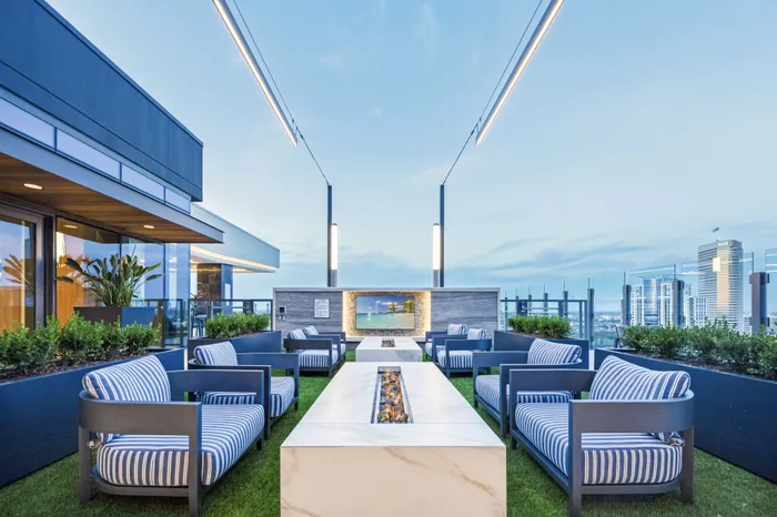 two fire places with four chairs at each on the roof top courtyard