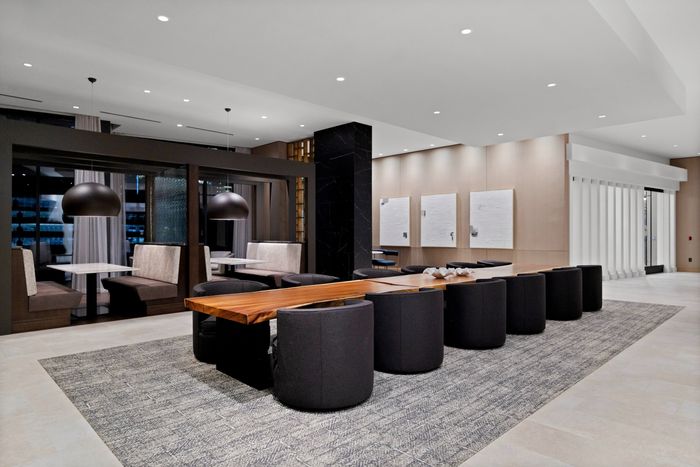 long coworking table with 12 chairs and banquette seating behind it
