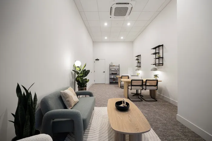 office space outfitted with two desks and sofa seating area