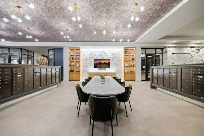 coworking space with 10-seater table, built-in shelves, tv, and mailboxes on either side