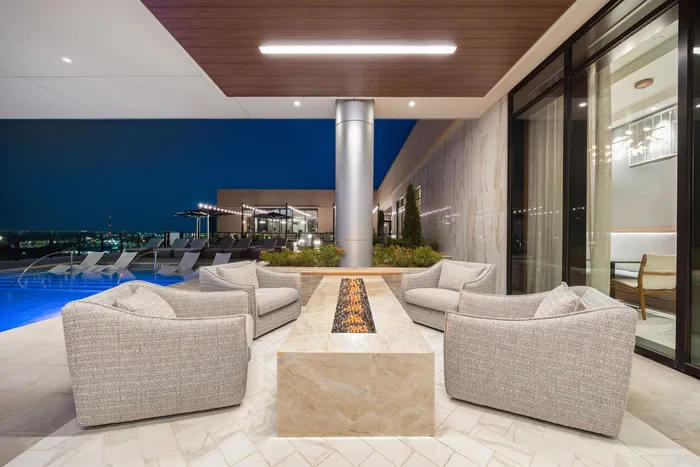 Sofa sitting with centre fireplace besides the pool on the terrace