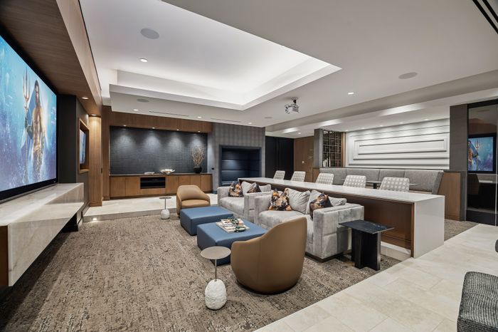Screening room with projector screen, a variety of lounge, counter. and booth seating