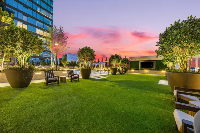 outdoor deck of apartment high rise with green lawn and lounge chairs