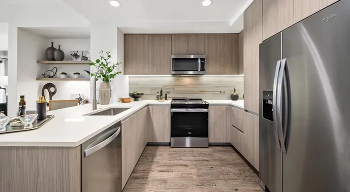 Modern kitchen with sleek stainless steel appliances, elegant wood cabinetry, and stylish open shelving.