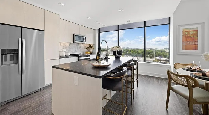 Modern kitchen with sleek appliances, elegant island seating, and floor-to-ceiling windows showcasing breathtaking views.