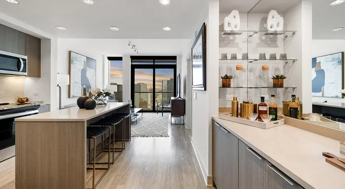 Chic modern apartment kitchen with sleek countertops, elegant decor, and a stunning cityscape view.
