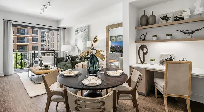 Luxurious open-concept living space featuring a chic dining area, elegant decor, and a bright seating area with a balcony view.