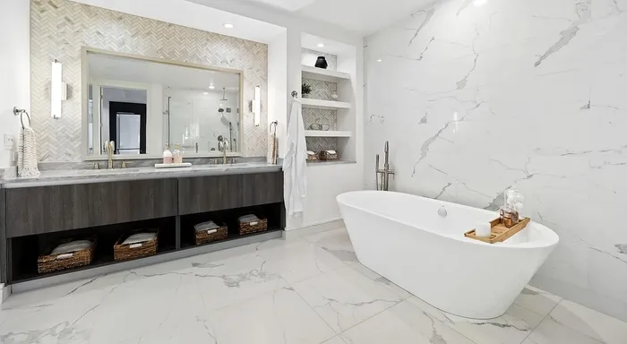 Luxurious bathroom with elegant freestanding bathtub, dual sinks, and chic herringbone tile accent wall for a spa-like retreat.