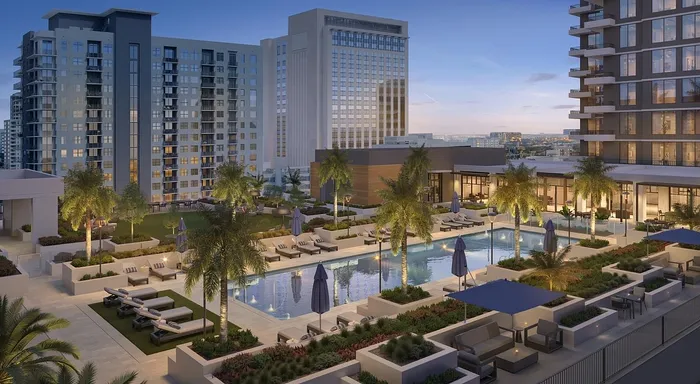 Stunning urban oasis featuring a luxurious pool surrounded by palm trees and elegant high-rise apartments, perfect for chic city living.