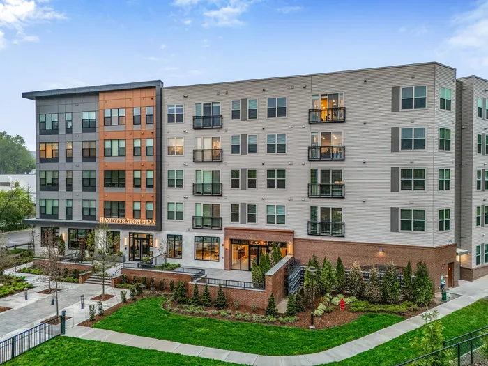 Modern apartment complex with stylish exterior, landscaped gardens, and inviting entrance, offering a vibrant community living experience.