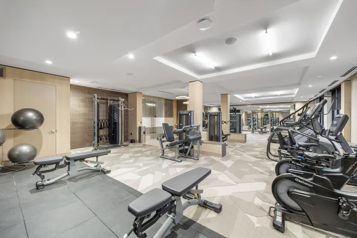 Modern and spacious gym with state-of-the-art equipment, sleek design, and ample lighting.