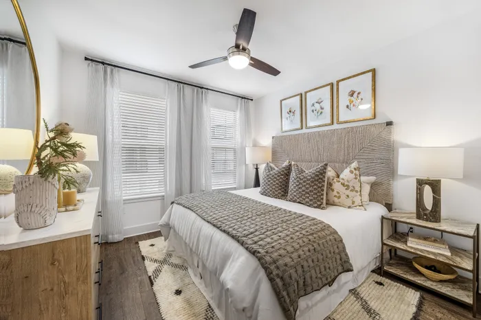 Chic and cozy bedroom with elegant decor, featuring a comfortable bed with patterned cushions, stylish wooden furniture, and soft ambient lighting.