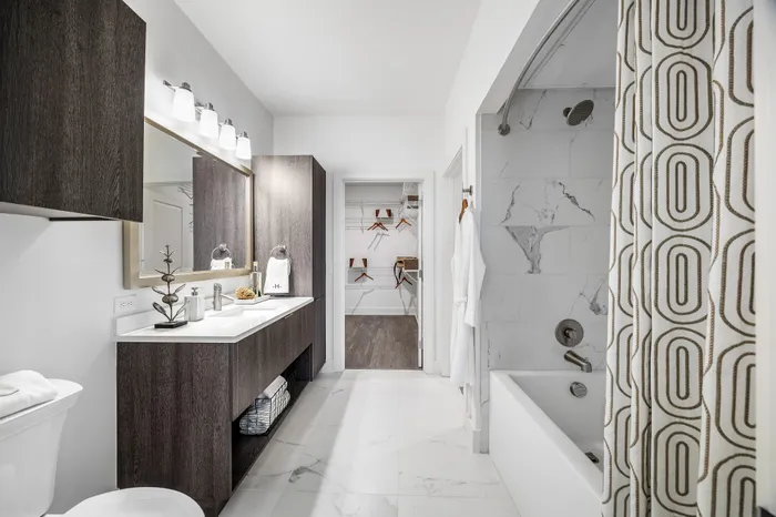 Elegant bathroom with sleek modern fixtures, spacious vanity, and walk-in closet.