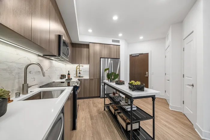 Modern gourmet kitchen with sleek cabinetry, marble backsplash, and spacious island, accented with warm hardwood floors and stainless steel appliances.