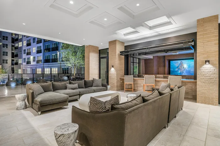 Luxurious rooftop patio with modern seating, chic brick accents, and stunning city views, perfect for entertaining.