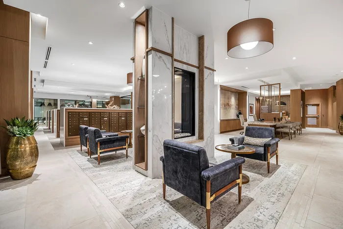 Elegant lobby with modern seating, plush armchairs, and a stylish design featuring wood and marble elements, perfect for a warm welcome.
