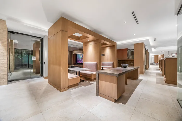 Luxury apartment interior showcasing modern wooden design with cozy dining booths and a sleek, polished floor.