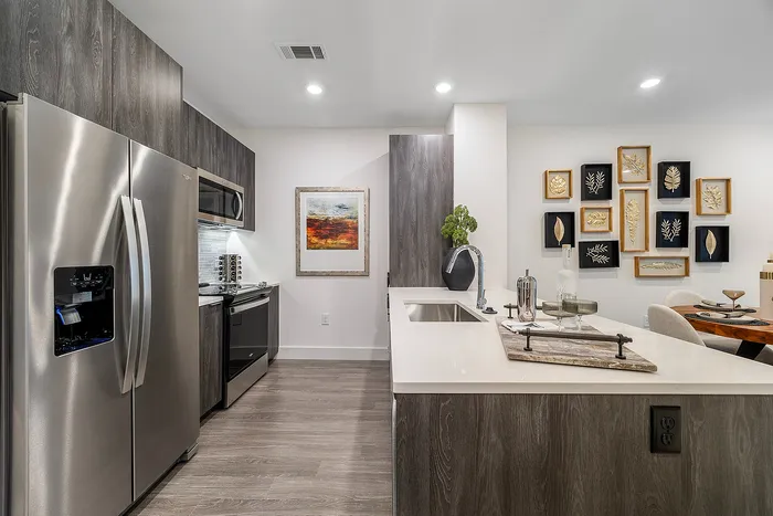 Modern kitchen with sleek stainless steel appliances, elegant cabinetry, and contemporary wall art, offering a sophisticated and inviting atmosphere.