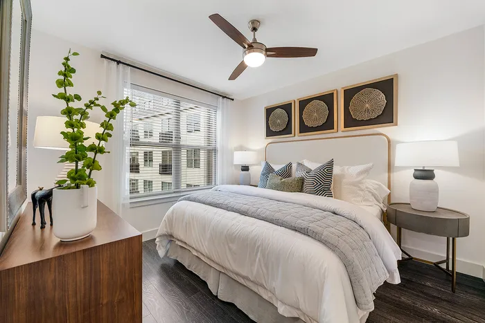 Chic bedroom with modern decor, featuring a cozy bed, stylish artwork, and elegant lighting, creating a serene atmosphere.