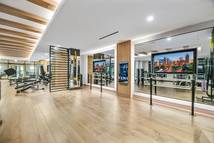 Luxurious and modern gym with state-of-the-art equipment, mirrored walls, and bright lighting, perfect for fitness enthusiasts.