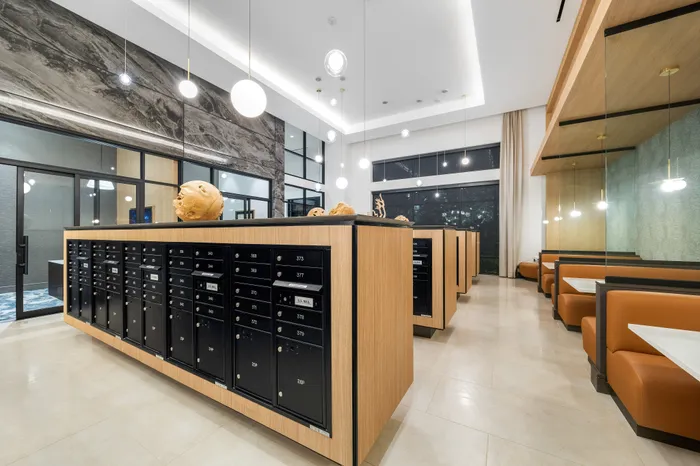 Modern and elegant apartment lobby featuring sleek mailboxes, stylish lighting, and cozy seating areas for a welcoming ambiance.