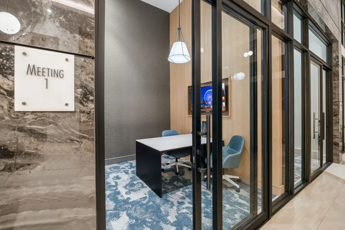 Elegant meeting room with modern decor, featuring plush seating, a contemporary table, and vibrant artwork. Ideal for creative discussions and professional gatherings.