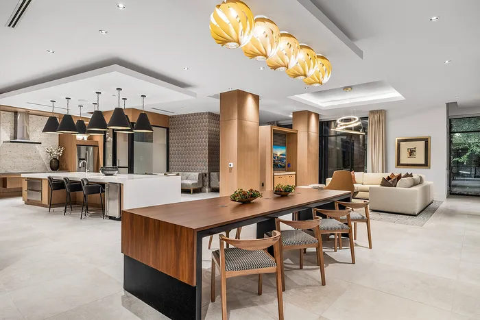 Modern open-plan kitchen and living area with stylish pendant lighting, sleek wooden accents, and elegant furnishings.