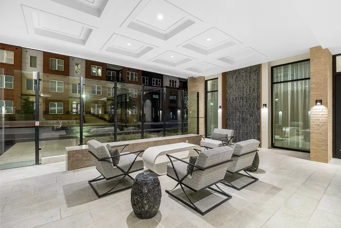 Contemporary lobby lounge with modern seating, sleek design, and large floor-to-ceiling windows providing a view of the urban landscape.