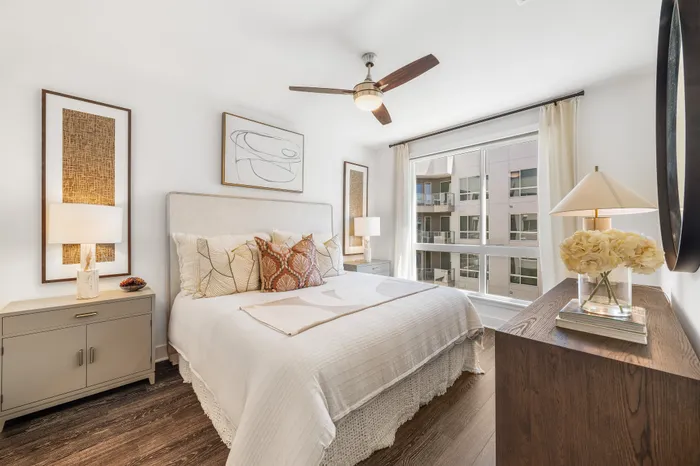 Bright and inviting bedroom with modern decor, large windows, and elegant furnishing, offering a serene view.