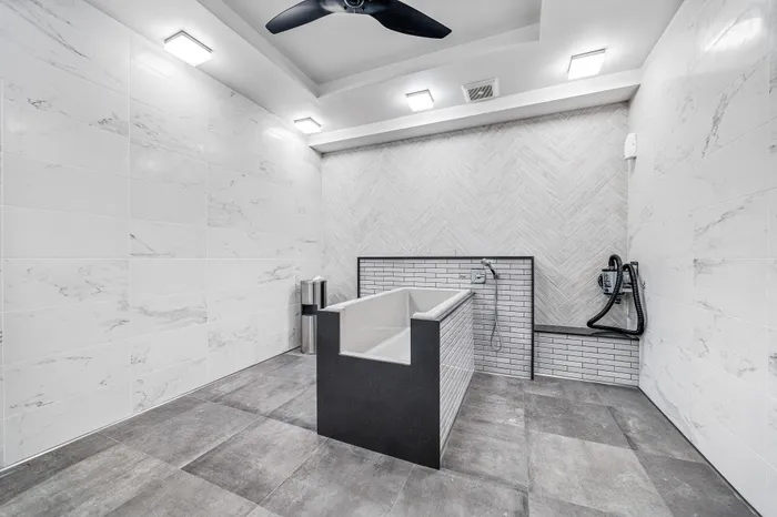 Contemporary bathroom design featuring elegant marble tiles, modern soaking tub, and sleek fixtures under soft ambient lighting.