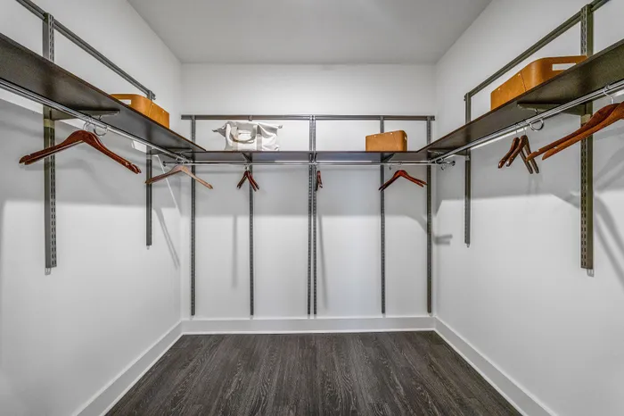 Spacious walk-in closet with sleek shelving and plenty of hanging space, perfect for organizing stylish wardrobes.