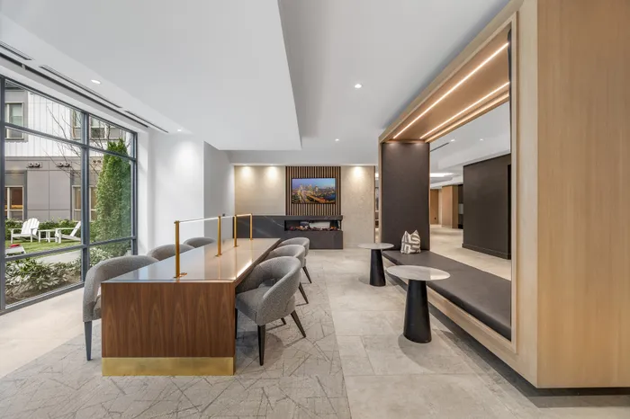 Sophisticated communal space with large windows, elegant seating, and a modern fireplace, perfect for relaxation and gatherings.