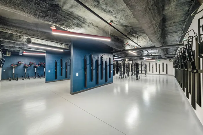 Modern and spacious indoor bike storage area with sleek design and ample lighting, perfect for urban cyclists.